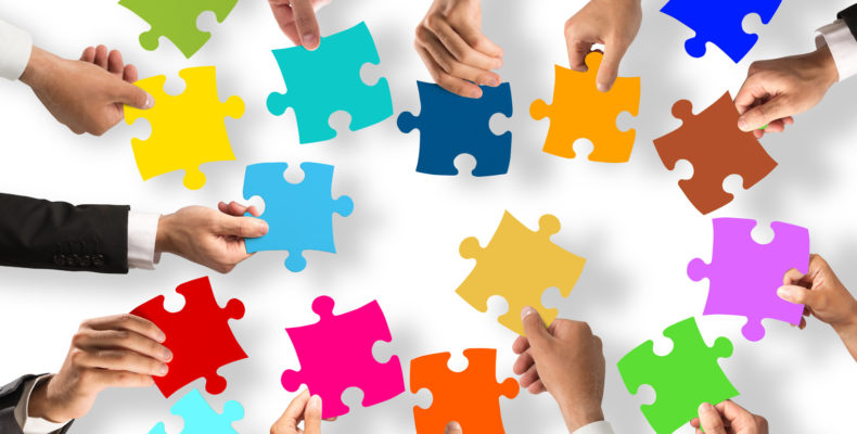 Business people join the colorful puzzle pieces. Concept of teamwork and integration